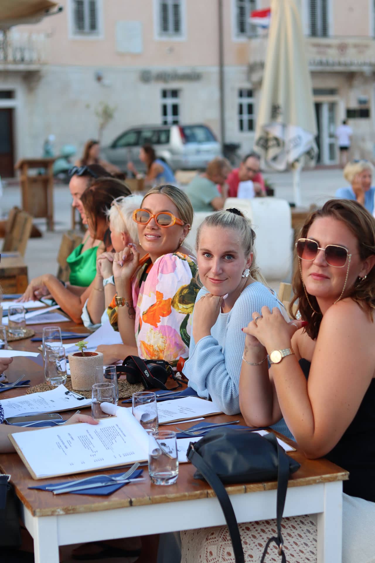 Tjejer sitter vid middagsbord och väntar på maten.