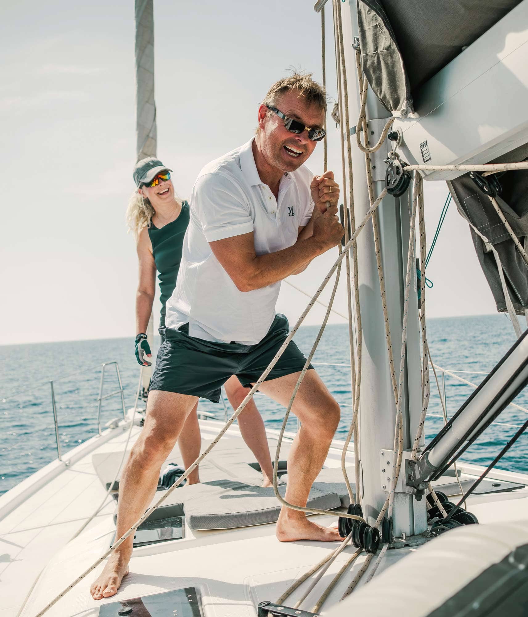 Skeppare drar i en tamp vid masten och en glas gäst kikar på bakom.