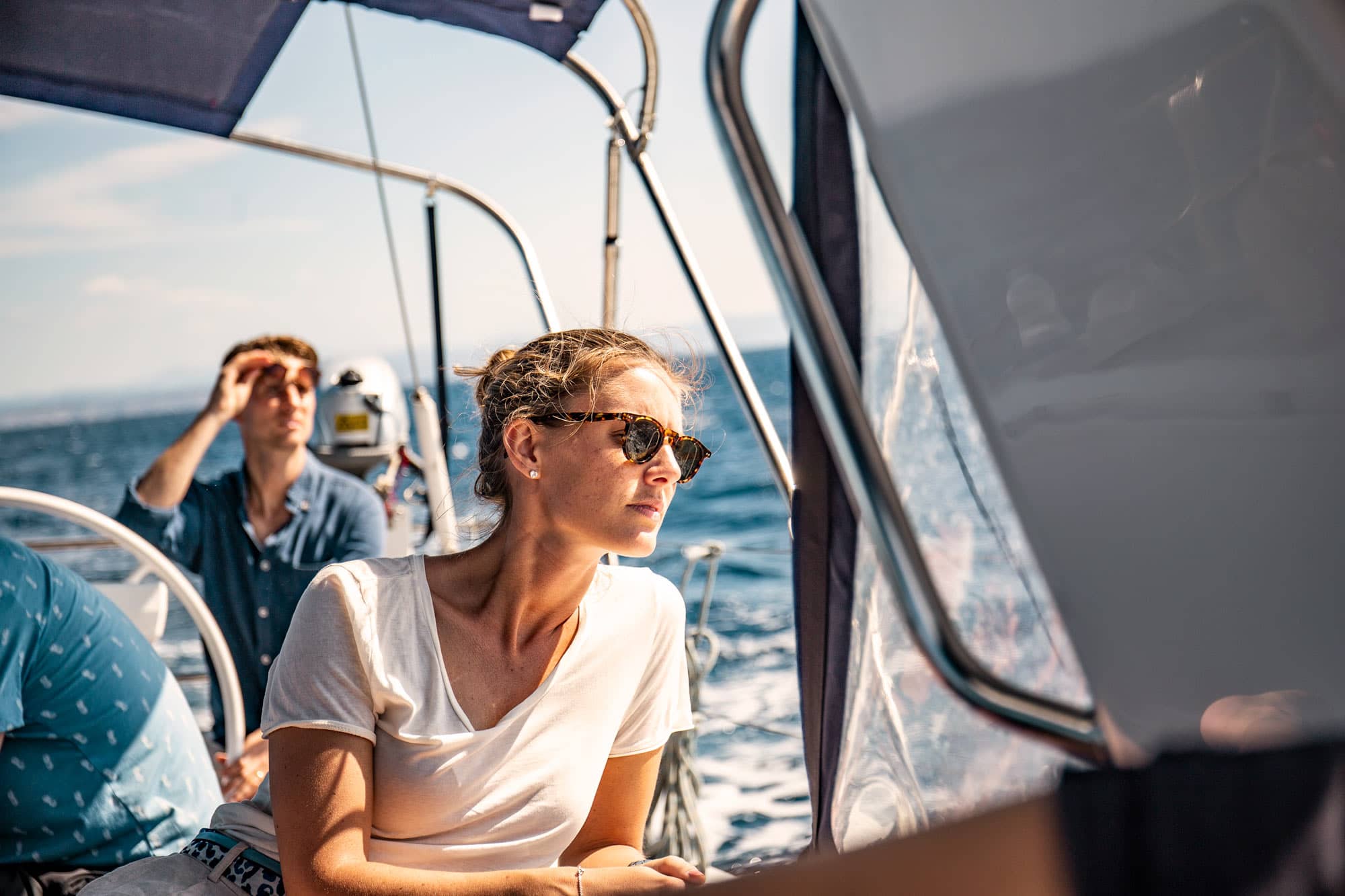 Frau und Mann mit Sonnenbrille blicken über das Meer.