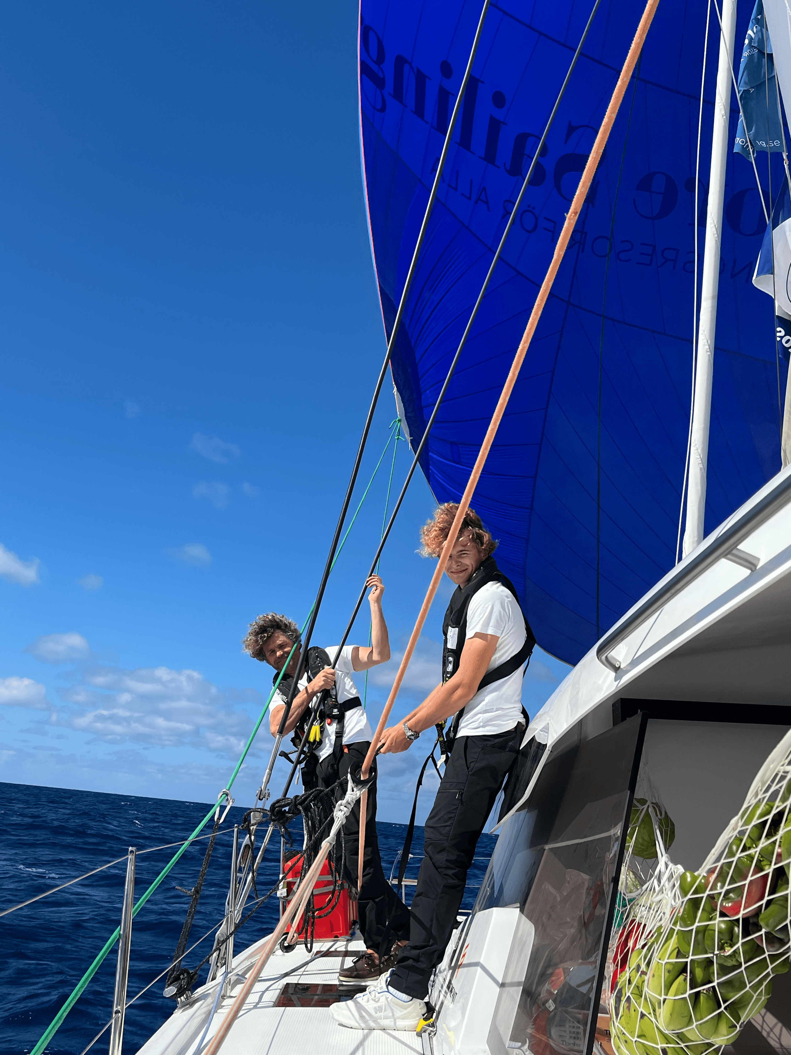 Två kursdeltagare hissar segel 