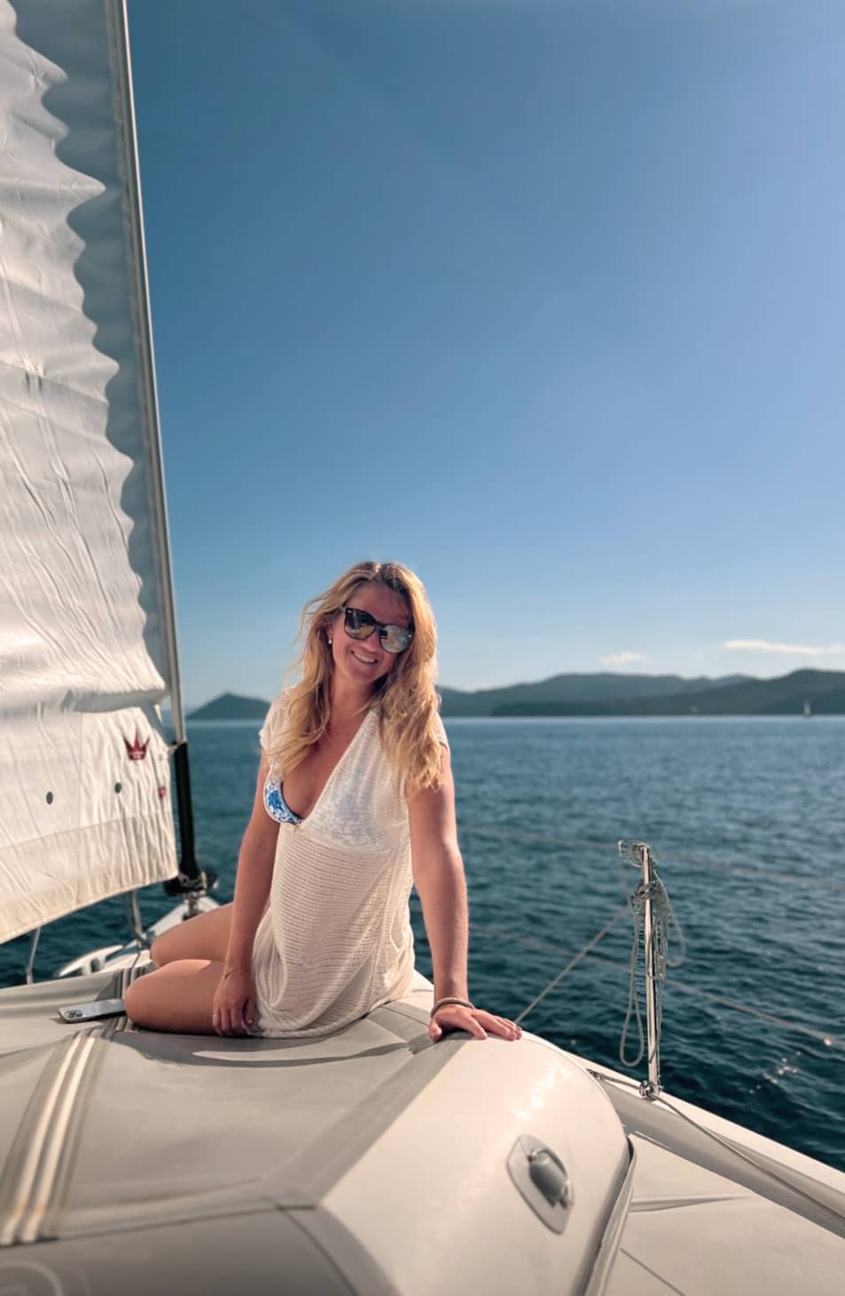 Skipper og vært smiler, mens de sejler