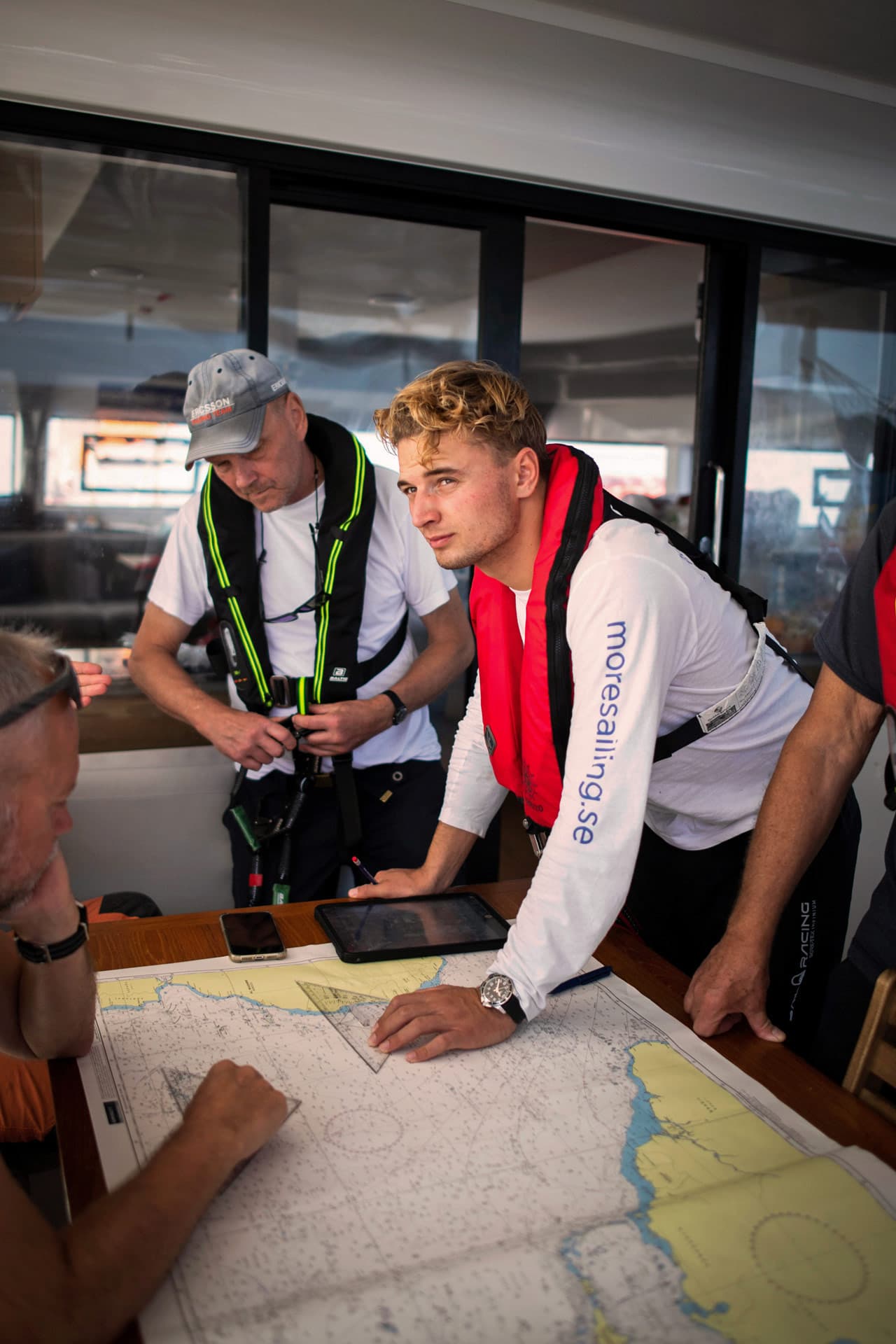 Die Crew ist um eine Seekarte versammelt und plant eine Route