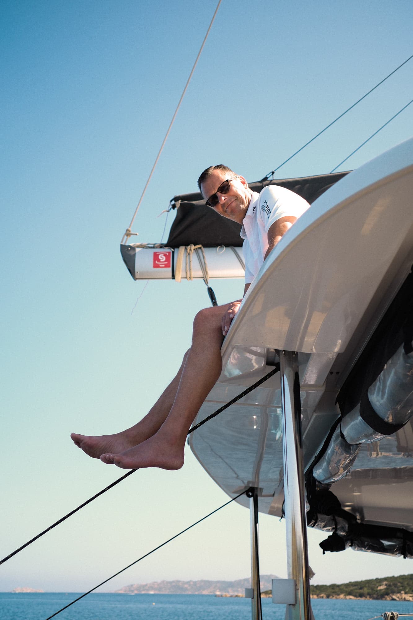 A man sitting on the roof of a catamaran