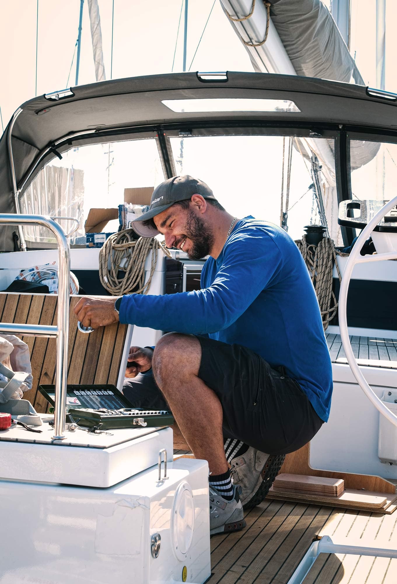 Ein Techniker in blauem Pullover, der auf dem Boot eine Luke repariert