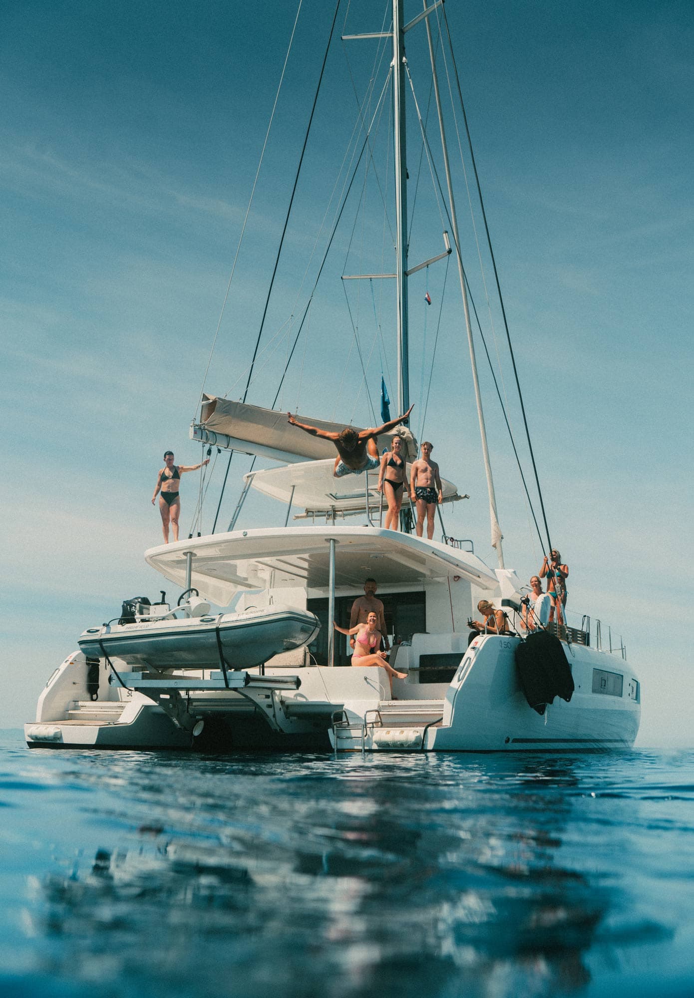 Acht Gäste schauen zu, wie ein Gast vom Deck ins Meer springt