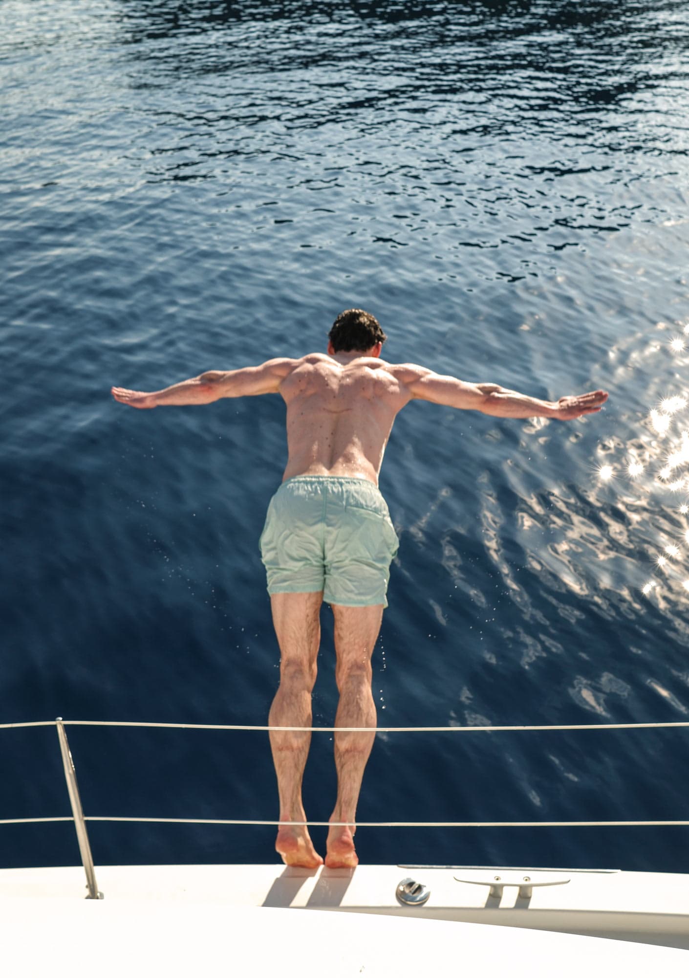 A man dives into the blue sea