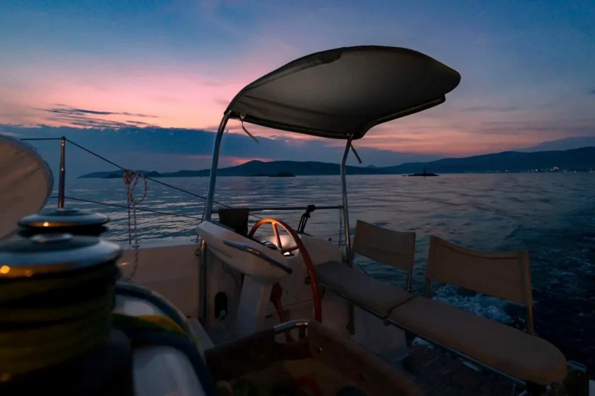 The helm of the Excess 15 catamaran at twilight.