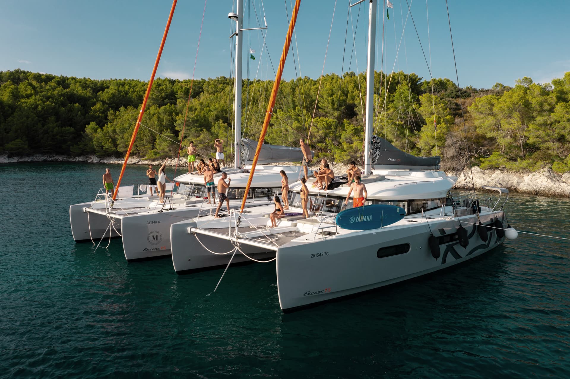 2 katamaraner bredvid varandra med många människor på i en vik