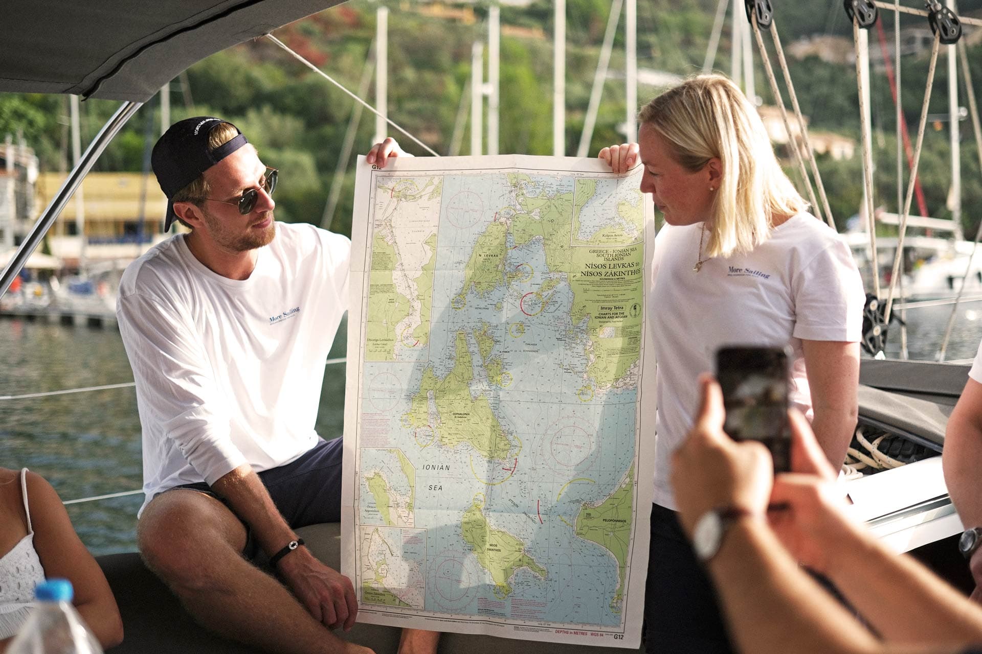 Skipper and host show the sailing route on a nautical chart