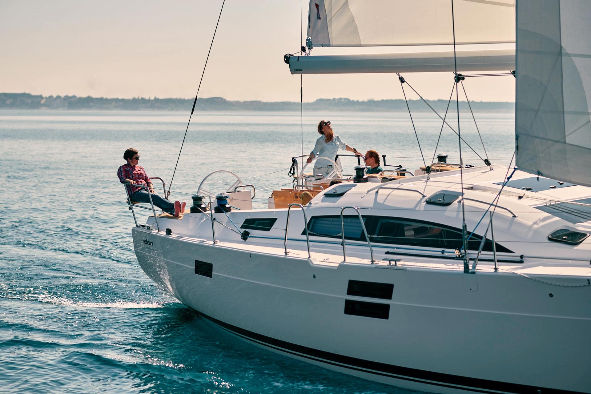 Three people sailing on the Elan Impression 50.1 monohull. 