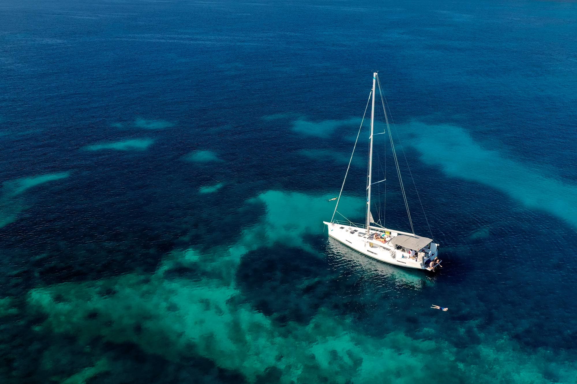 Swimming break, with guests swimming as the boat lies moored at sea