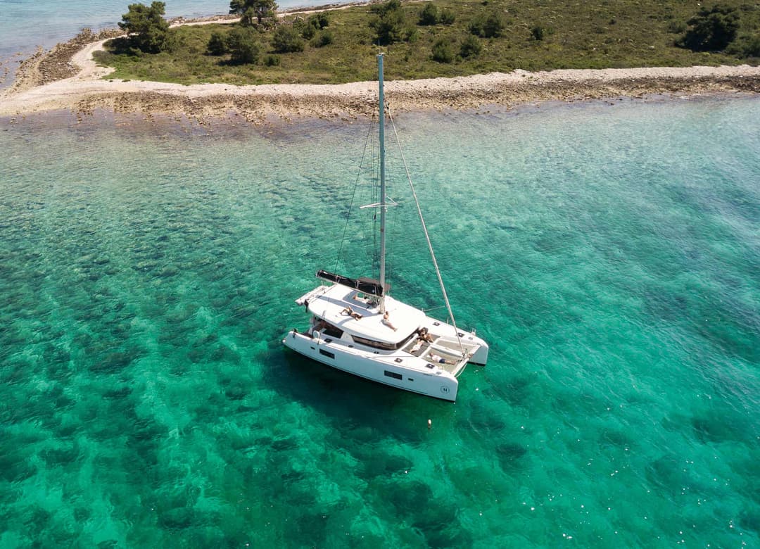 Eine luxuriöse Lagoon 42 in einer türkisfarbenen Badebucht