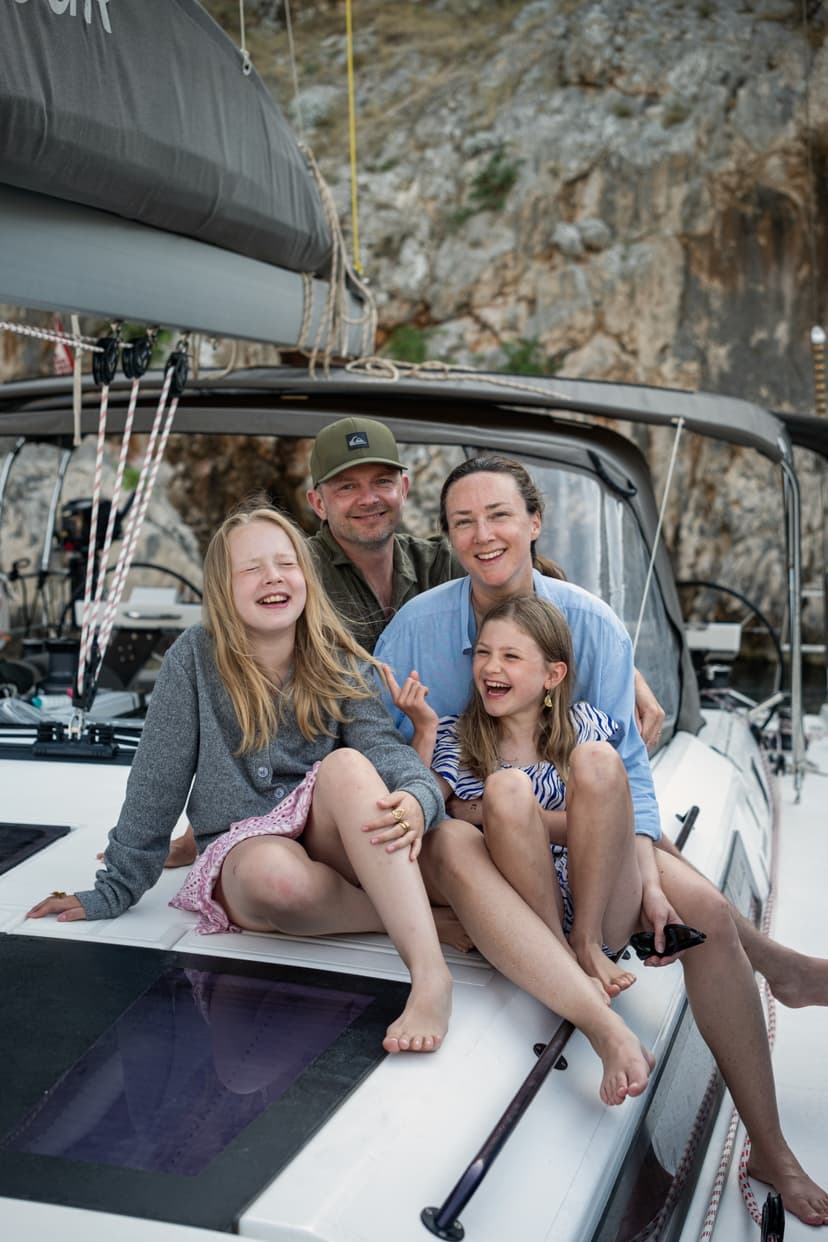 2 vuxna och 2 barn sitter på däck