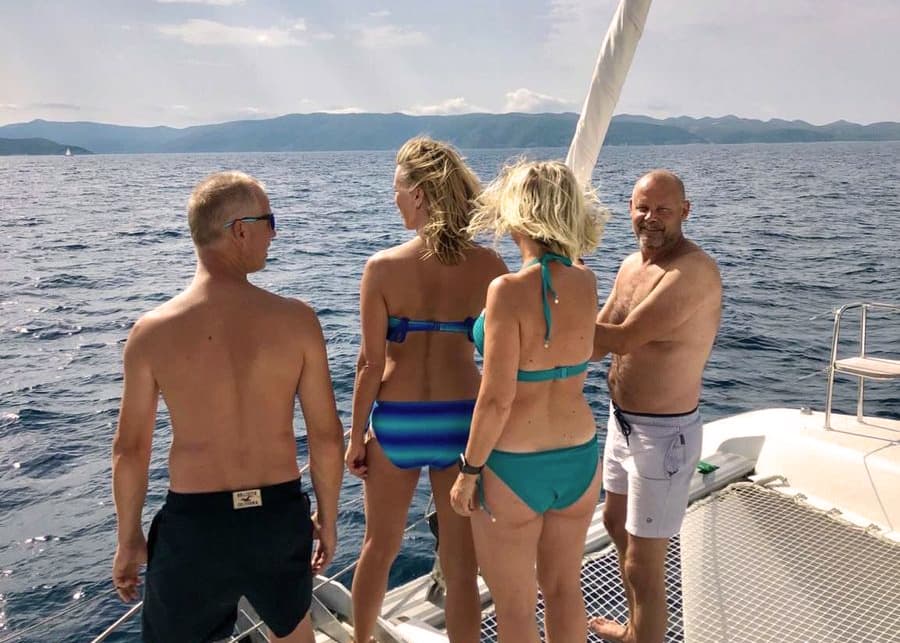 Fyra vuxna står i fören på en segelbåt och tittar ut över havet.