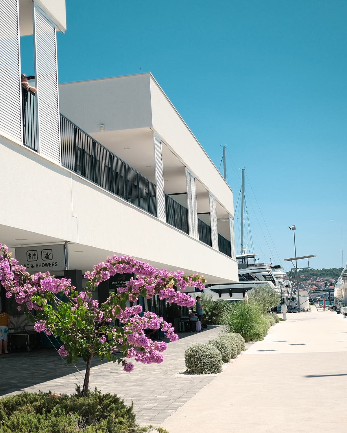 En vit byggnad med växter utanför. Där finns kontor och toaletter