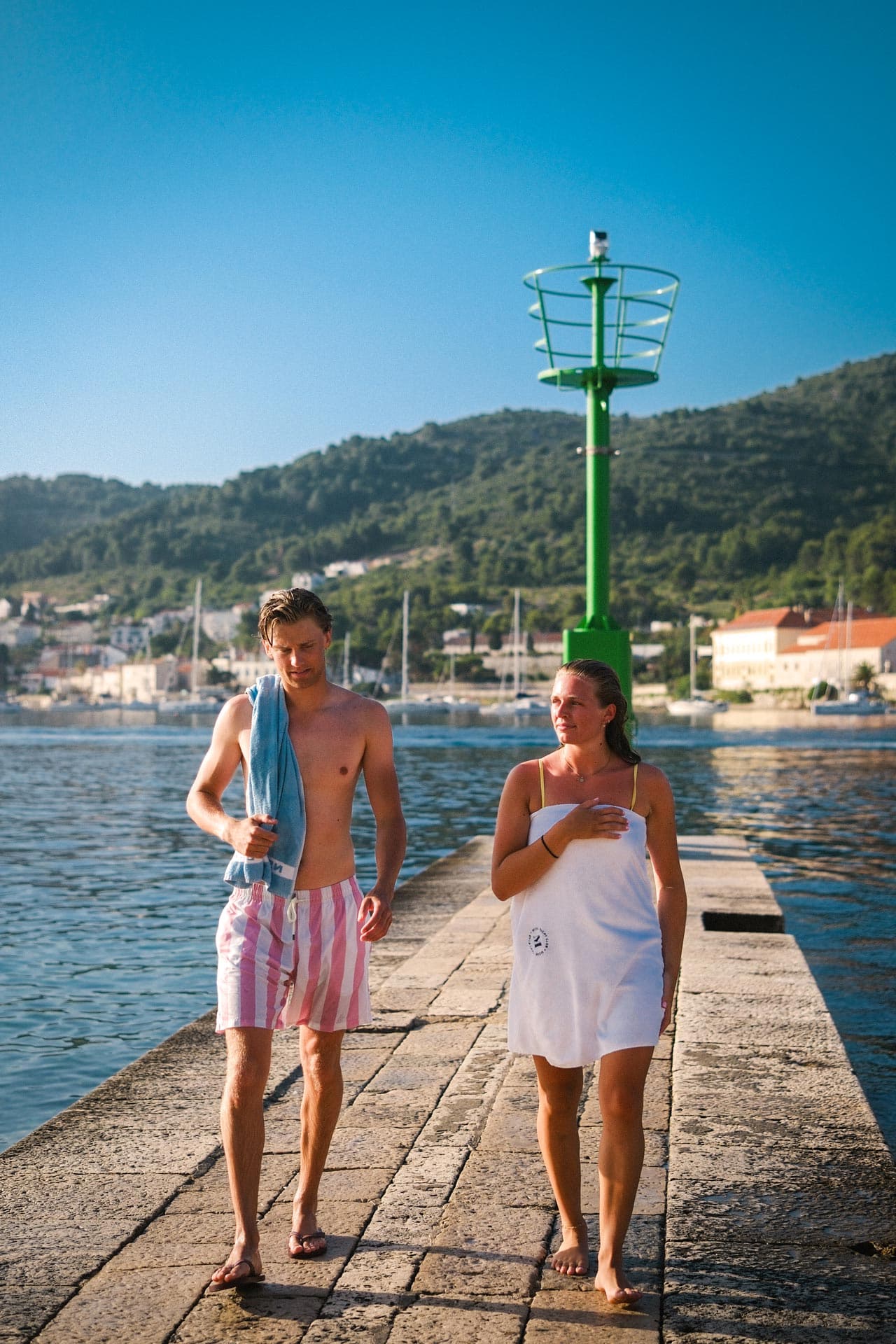 En kille och tjej som badat och är på väg in mot land