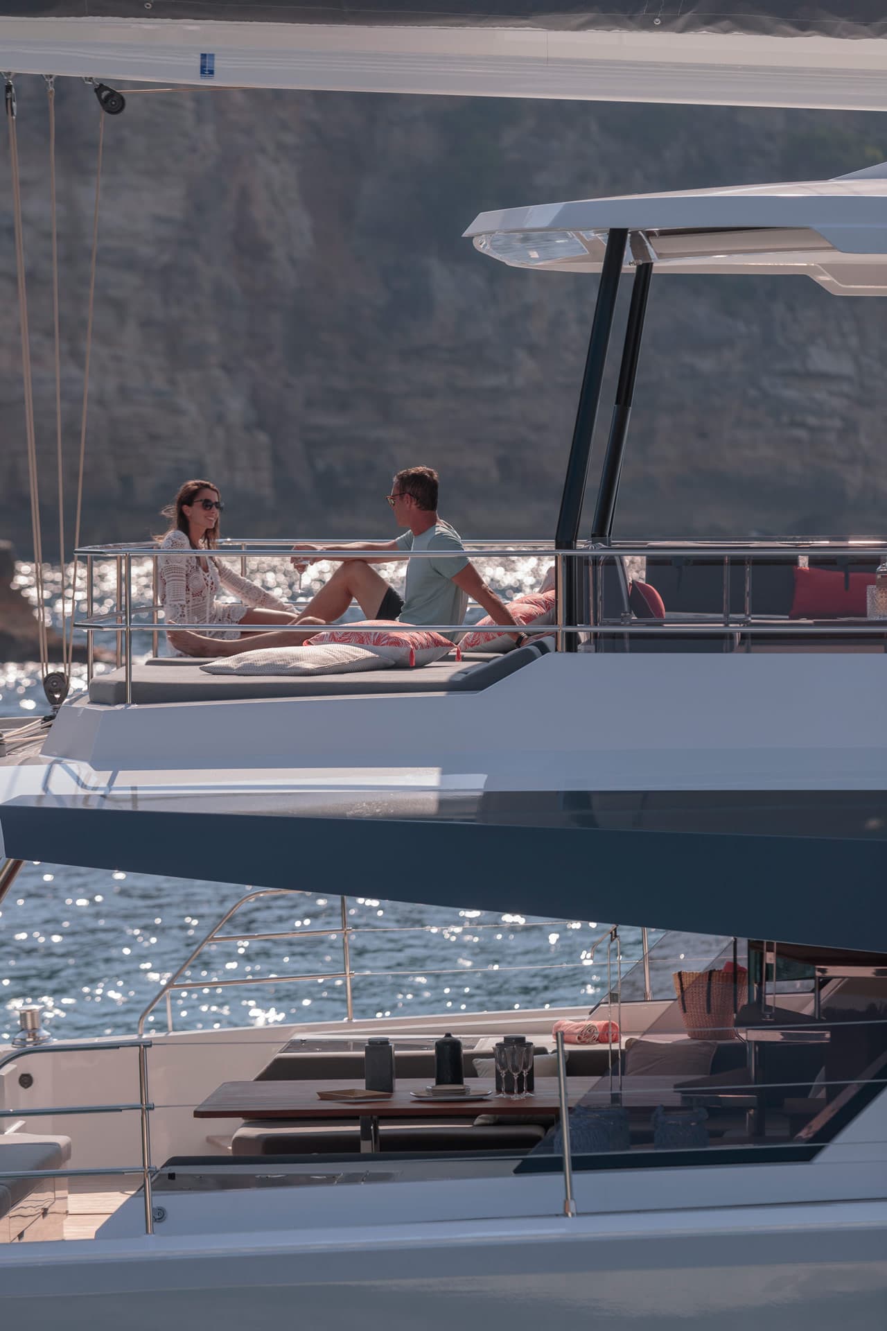 En man och en kvinna umgås på flybridge på en katamaran.