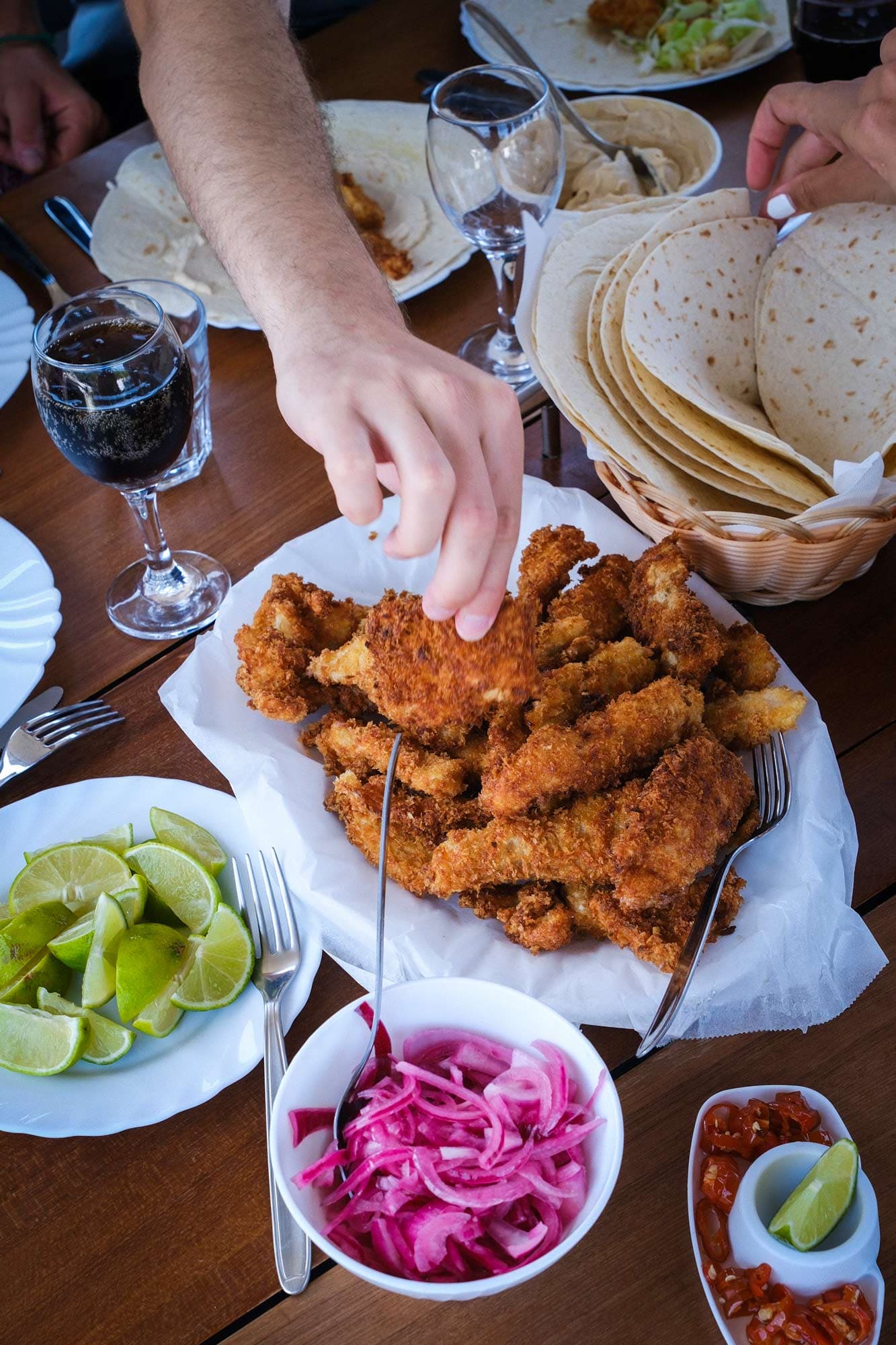Gedeckter Tisch mit frittiertem Fisch und Gemüse für Fisch-Tacos