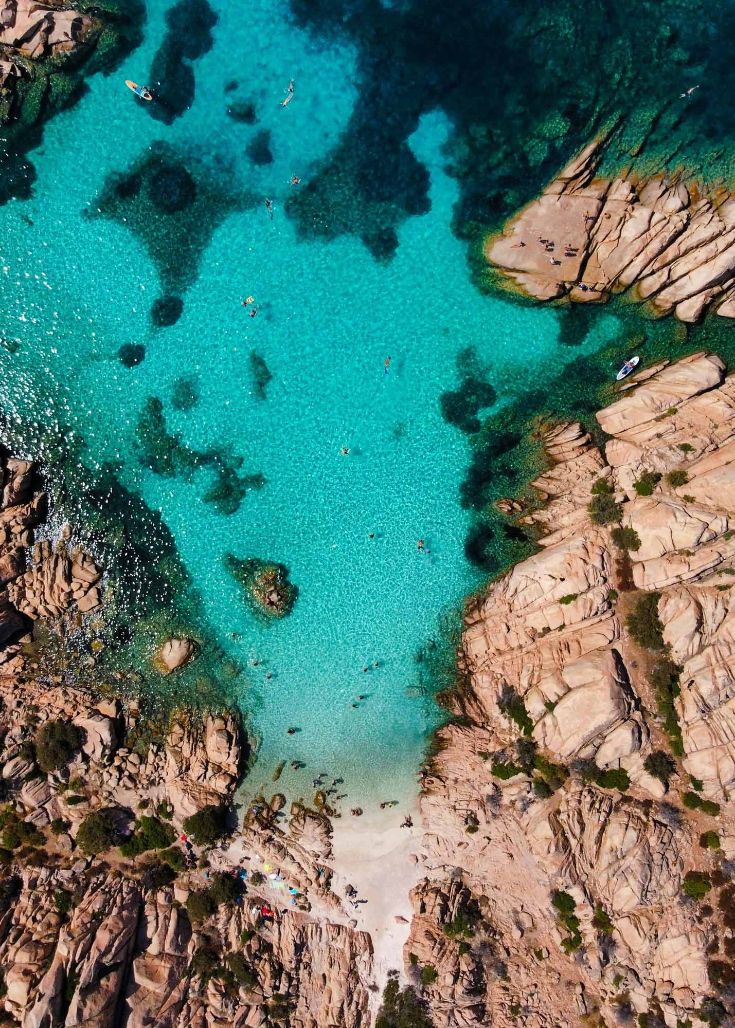 Large turquoise bay in Caprera surrounded by cliffs