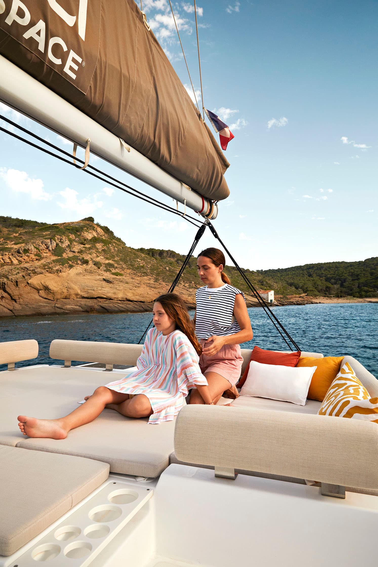 Mamma kammar håret på dotter ombord på en segelbåt.