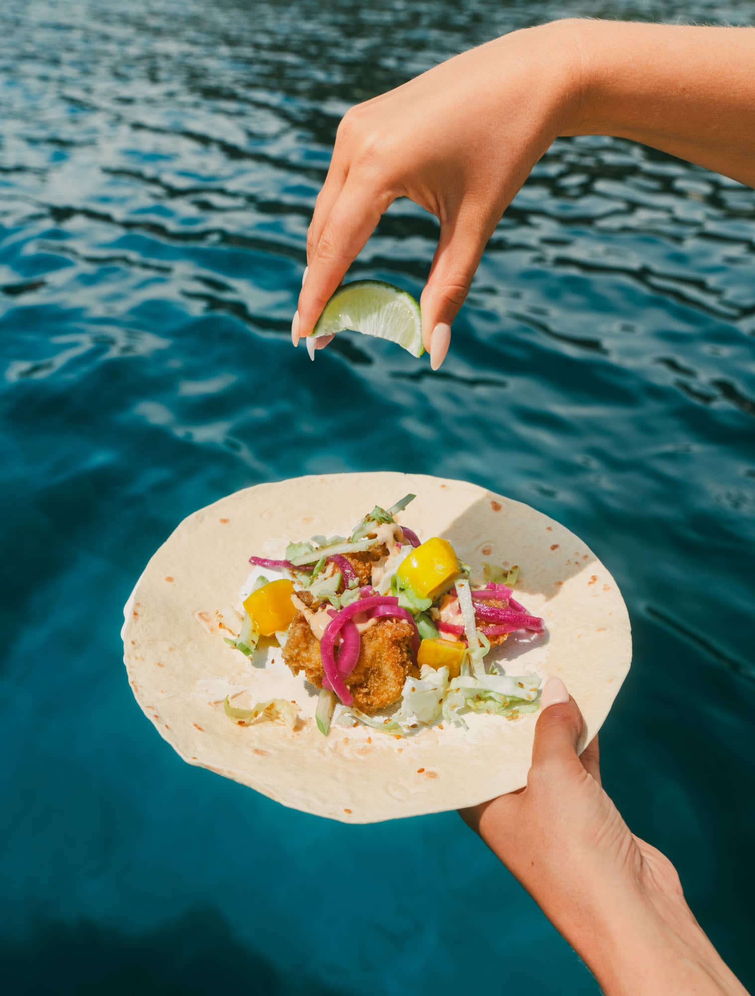 En fisk tacos med en limeklyfta pressandes över den