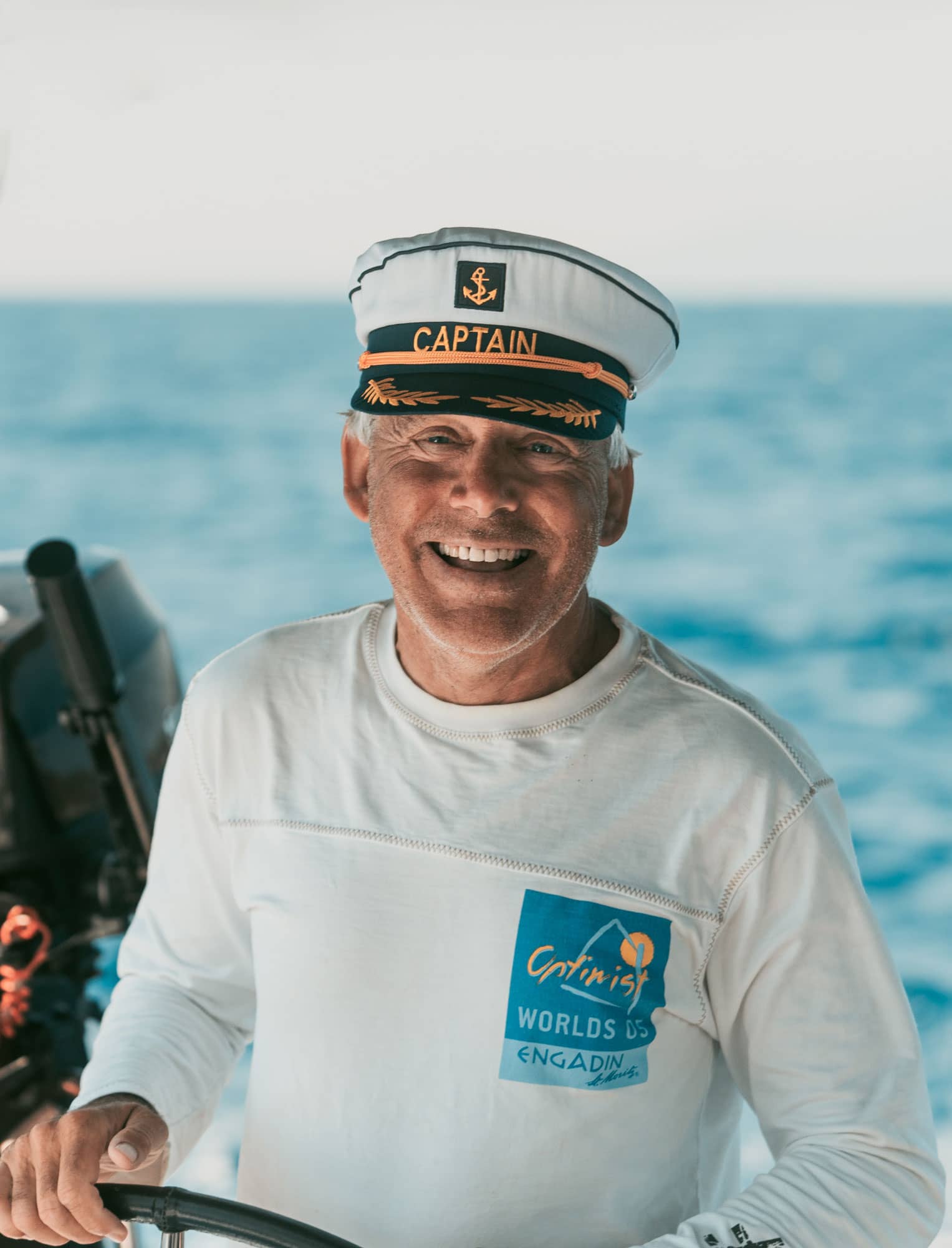 Kapten på segelbåten står med ett leende