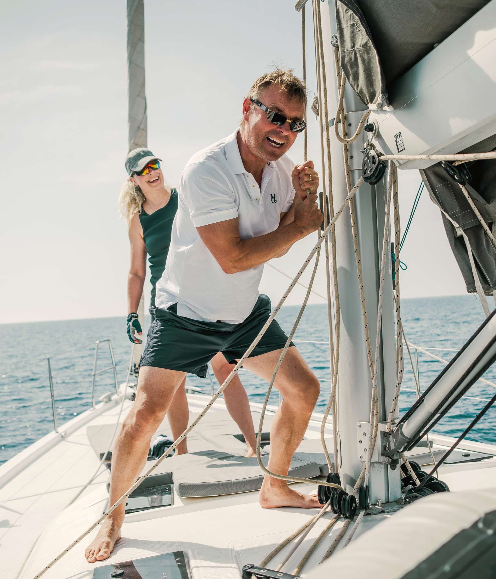 Skeppare drar i en tamp vid masten och en glas gäst kikar på bakom.