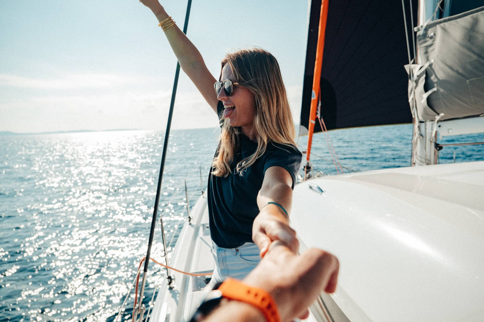 Eine Frau streckt einen Arm in die Luft und hält mit der anderen Hand die Hand eines Mannes