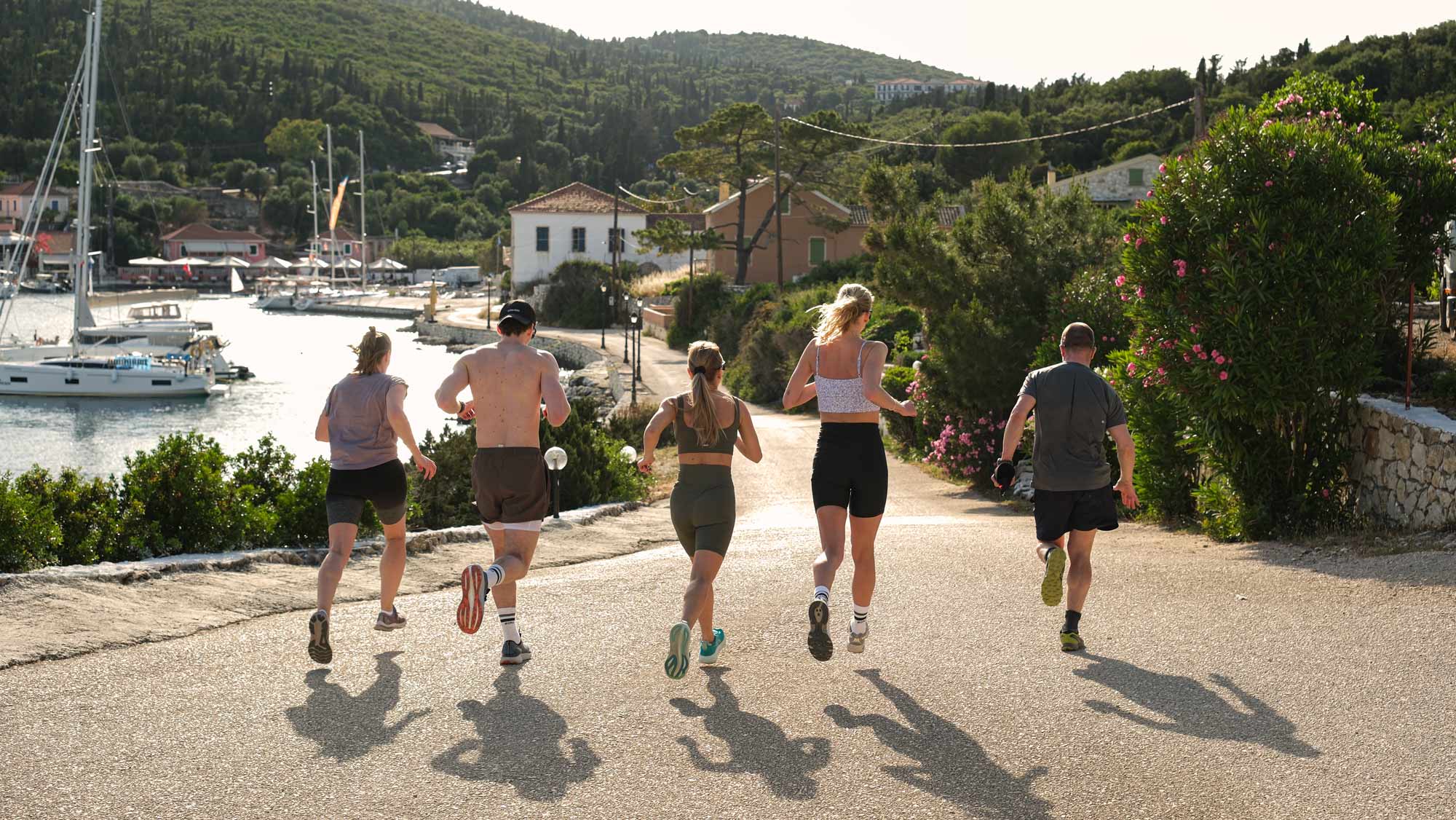 Fünf Personen joggen die griechischen Küstenstraßen entlang
