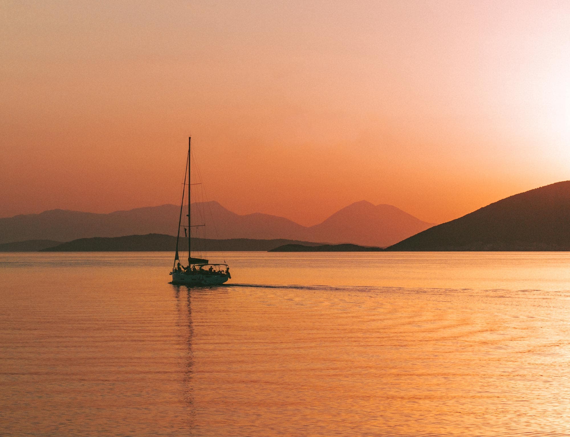 Segelyacht in orangefarbenem Sonnenaufgang