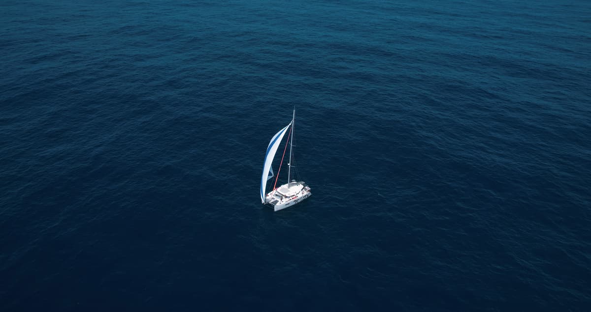 En bild på en segelbåt mitt ute på öppet hav.